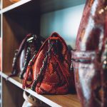 Fashion trend Snakeskin Print handbags on shelf in a store, shop. Sale, shopping, accessories concept.