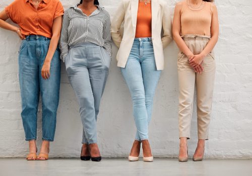 Feet and legs of team of business women standing together, doing teamwork and collaboration at work.